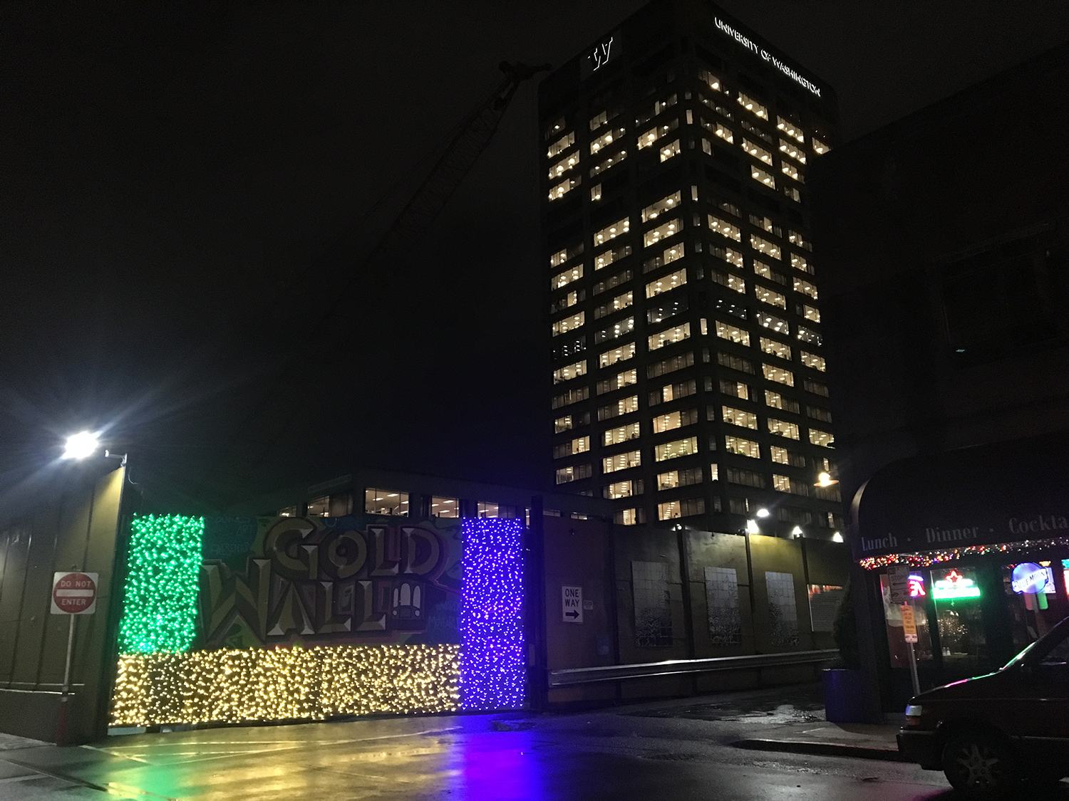 Festive lighting surrounds artist Emily Gussin’s Gold Wall sign at NE 43rd St. at the alley between "The Ave" and Brooklyn Ave NE.