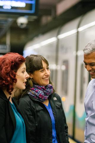 Riders chat at the Capitol Hill Station light rail station with Link train in the background.