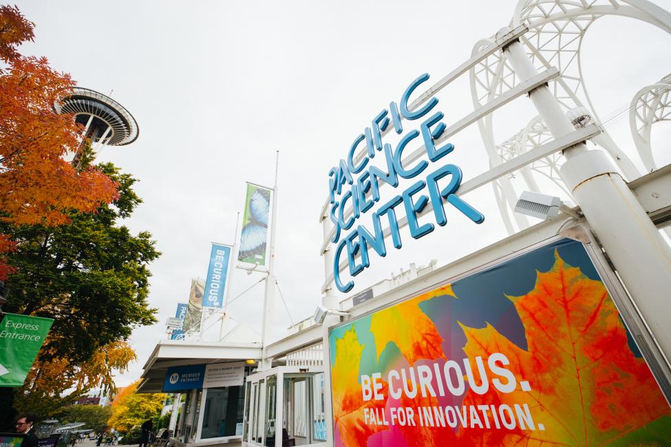 An image of the Pacific Science Center sign, with the Space Needle in the background.