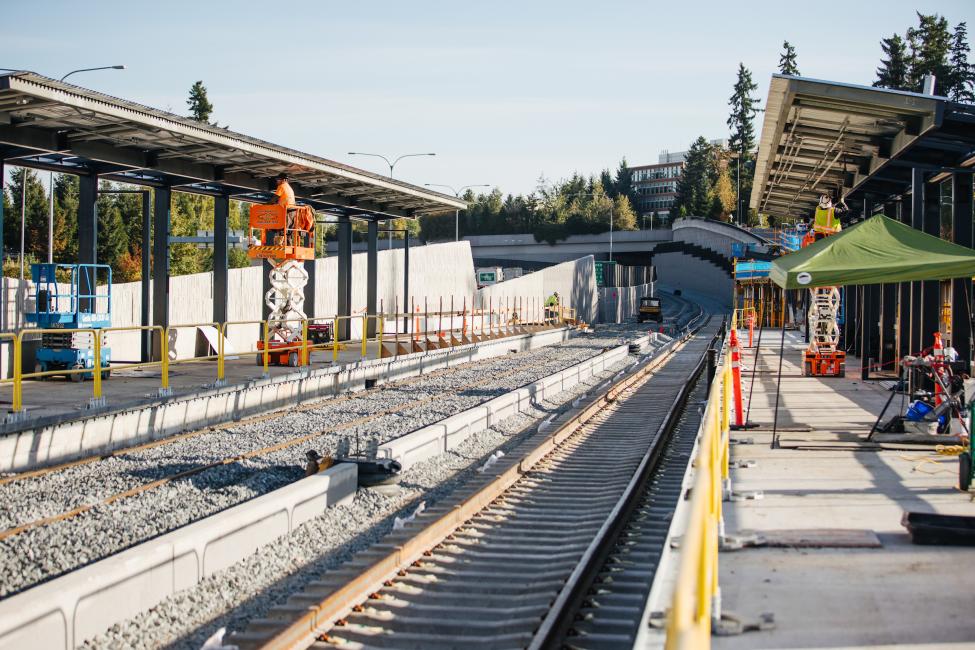 Workers can be seen in the background of this photo of Overlake Village Station, where rail and platforms are under construction.