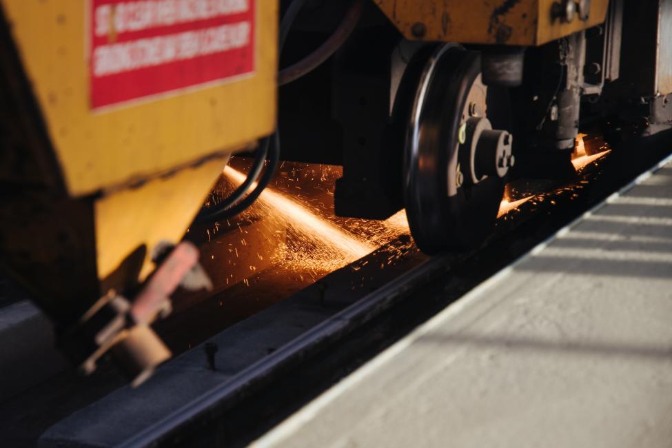 Sparks fly as a rail profiling machine travels down the tracks during the rail grinding process.