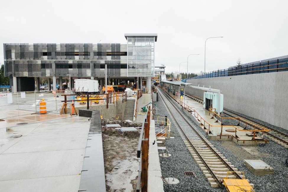 Construction fencing surrounds a new parking garage and future light rail station at Redmond Technology Center.