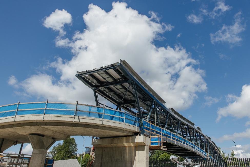 Blue skies and white clouds can be seen in the background of this photo of the entrance to the new pedestrian bridge at Overlake Village Station.