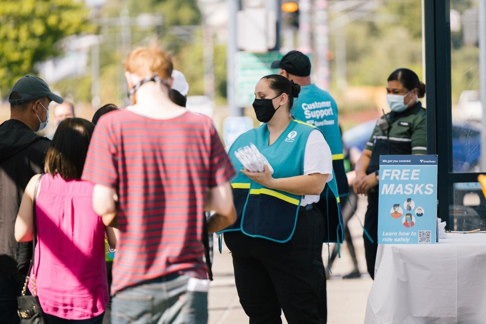 Ambassadors give away free reusable cloth masks at Rainier Beach Station in August. 