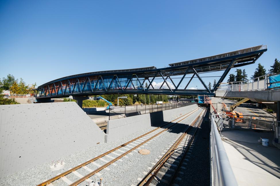 A new pedestrian bridge can be seen above SR-520 and train tracks connecting to Overlake Village Station.
