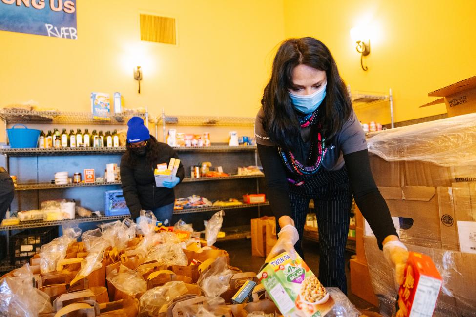 Two people fill bags of food at a food bank in the Rainier Valley in Seattle.