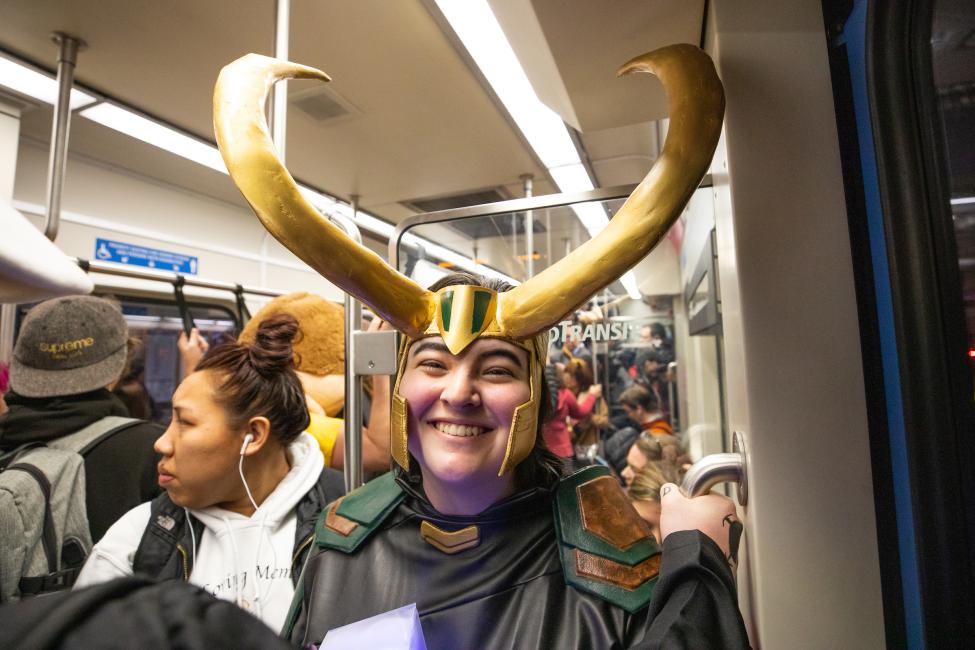 A passenger wears an ornate headpiece while riding the train to Comic Con