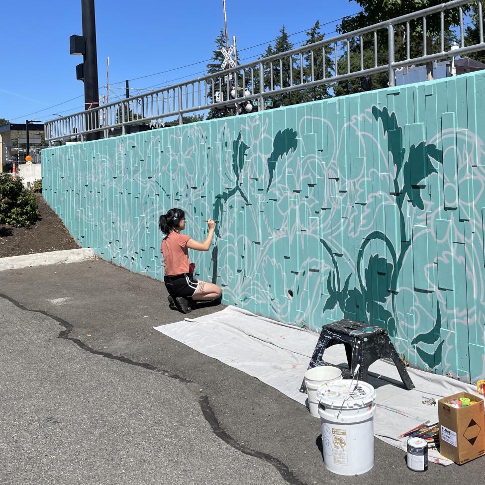 An artist paints a mural as part of the public art program of the BelRed Arts District