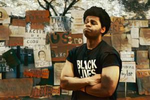 Mural showing a young Black man wearing a Black Lives Matter t-shirt looking at a wall of anti-racism protest signs