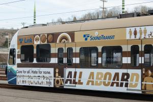 A Link train is wrapped in an advertisement that reads: "Care for all. Hate for none. All aboard." 
