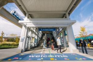 Riders pour through one of the Northgate Station entrances that features a giant "Welcome" matt on a sunny October day. 