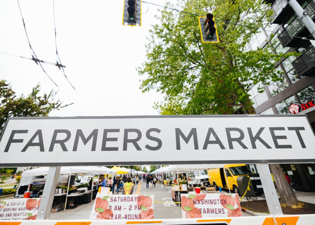 A large black and white sign reads "Farmers Market"