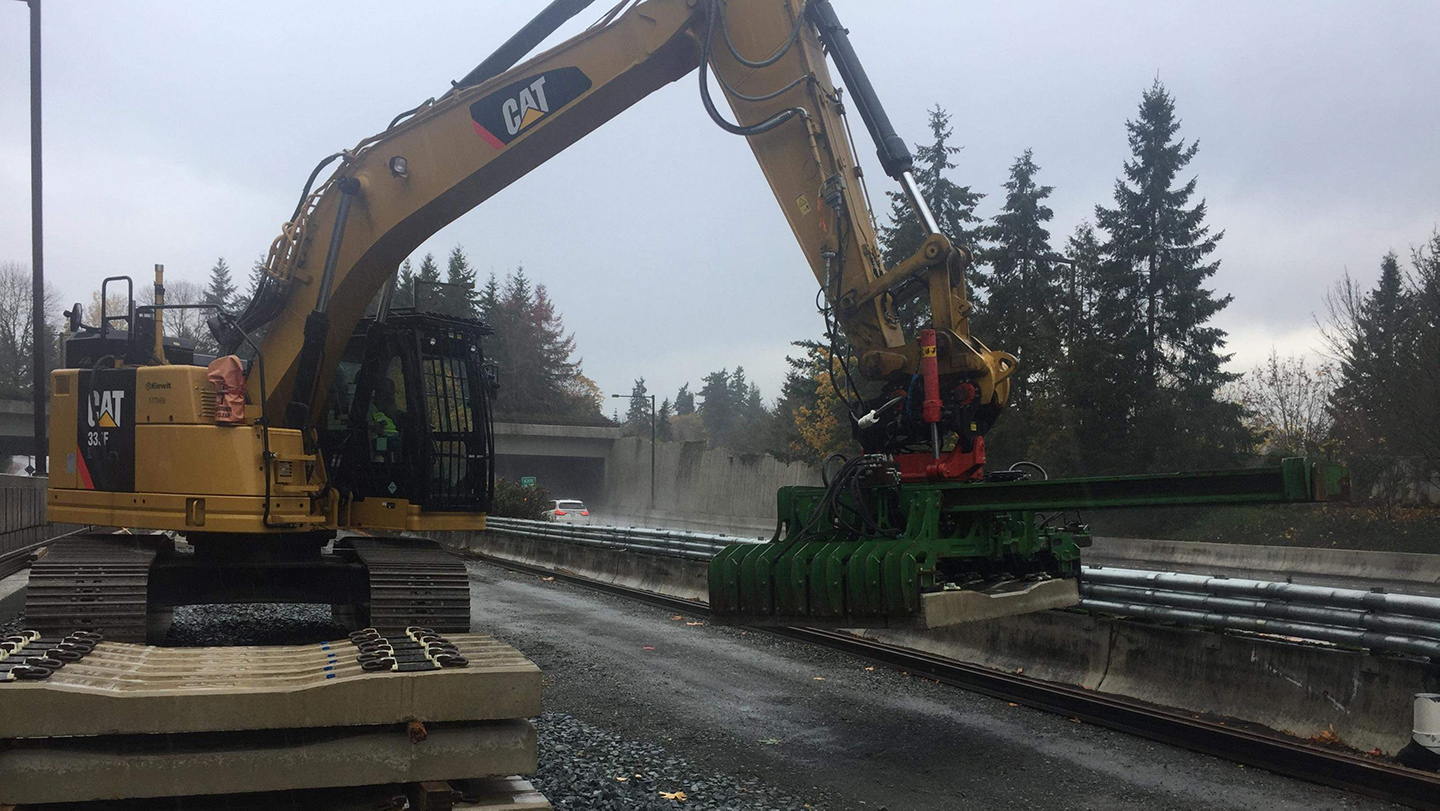 Concrete ties are lifted and placed by a forklift.