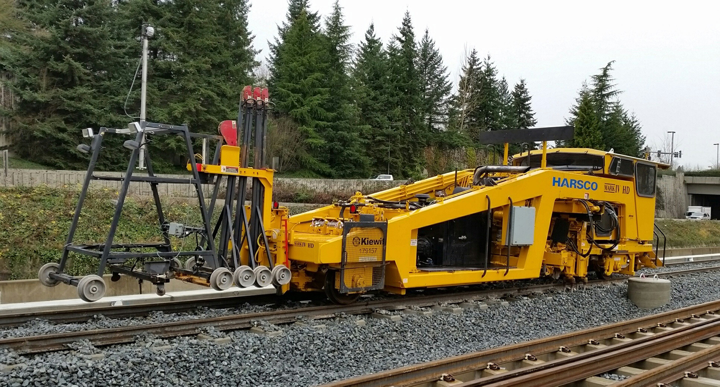 A machine called a 'tamper' uses lasers to measure the height of the rail lifts the concrete ties to the correct height.