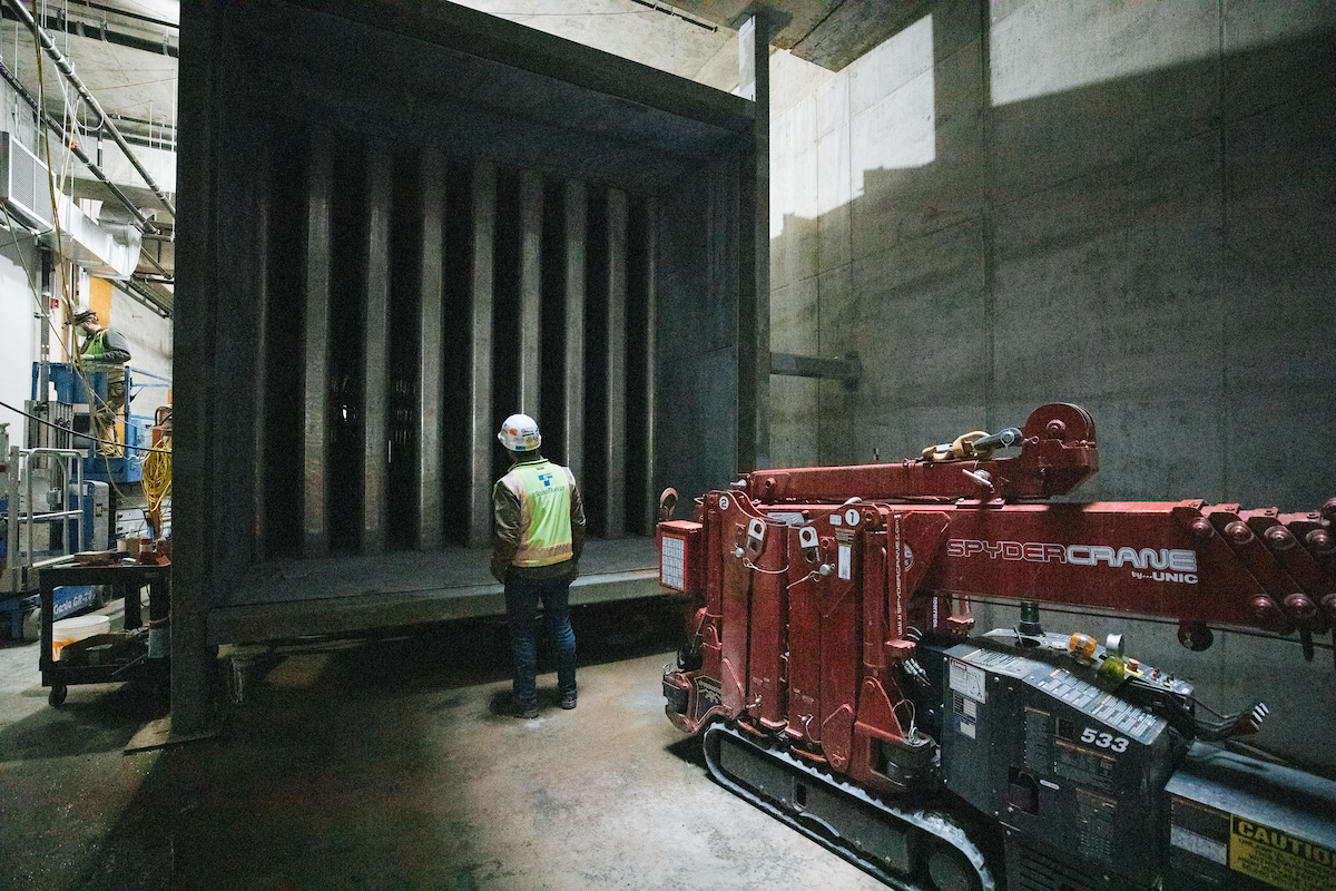 The vents for the giant fans that provide ventilation in Roosevelt Station and the tunnels dwarfs a construction worker.