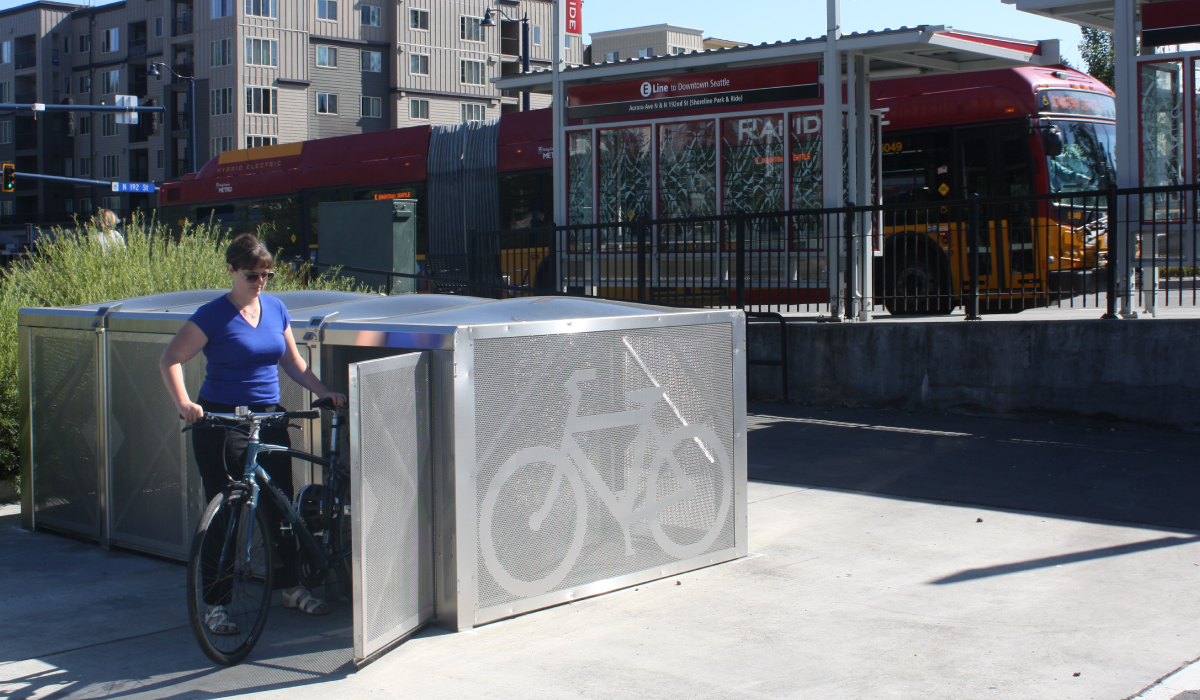 A bike rider loads his bike into an on-demand bike locker.