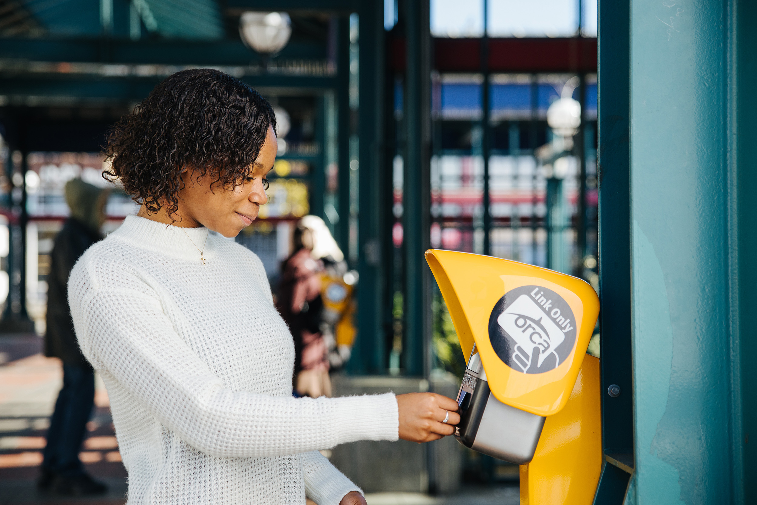 Sound Transit passenger taps their ORCA card at a Link station.