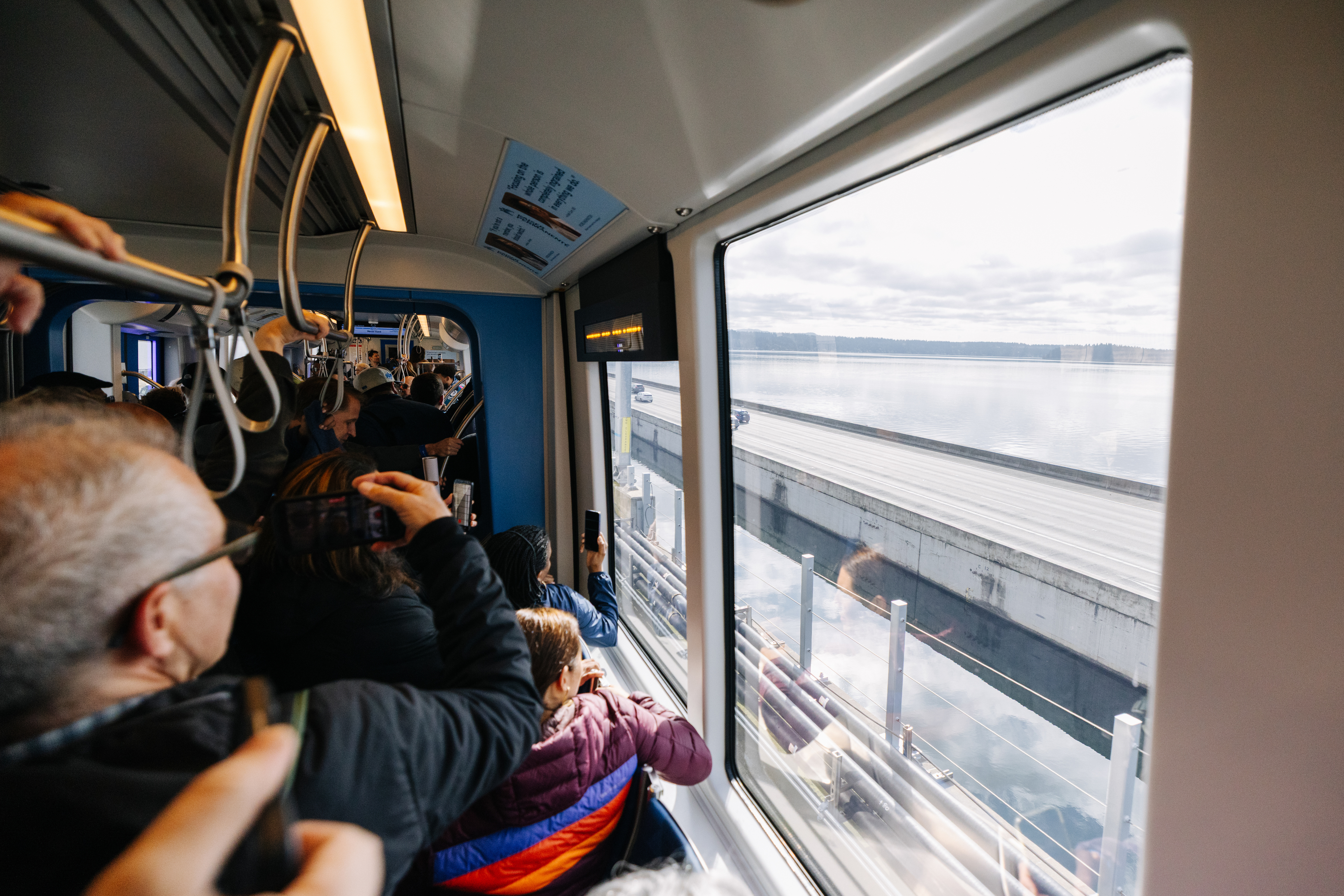 Passengers on a 2 Line train, overlooking Lake Washington, during the Crosslake opening day.