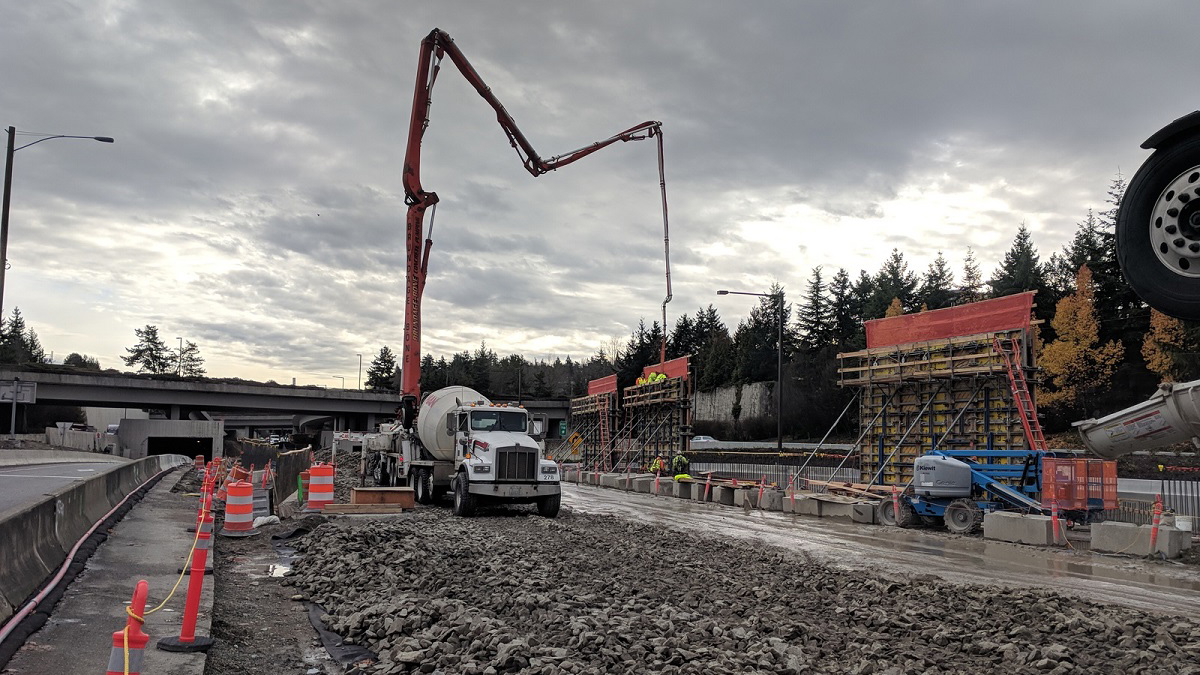 Crews pour concrete into the wood forms to create the sound walls at the Mercer Island station.