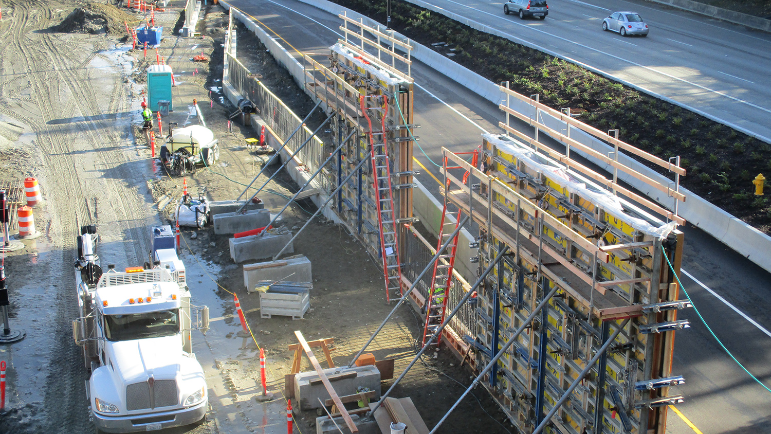 Poured concrete sound walls are left to cure before the wood forms are removed.