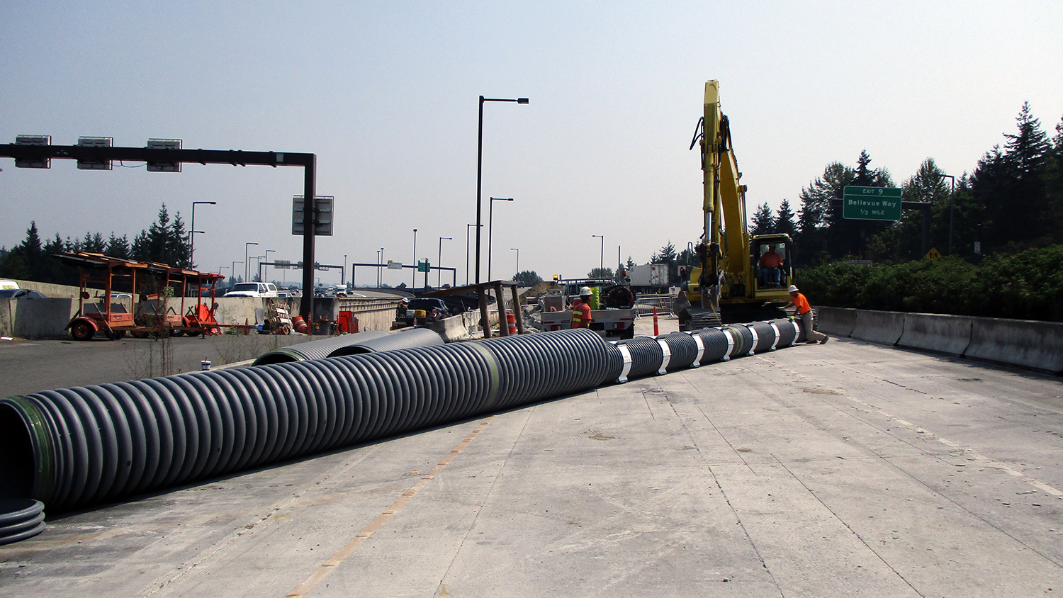 Crews install protective casing for utility lines near the future Mercer Island station.