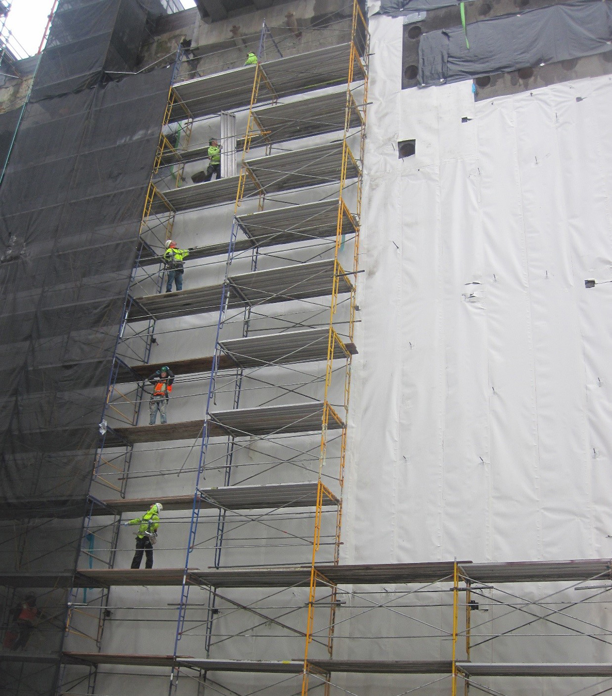 Workers build the scaffolding used to install the waterproofing around the Roosevelt Station box.