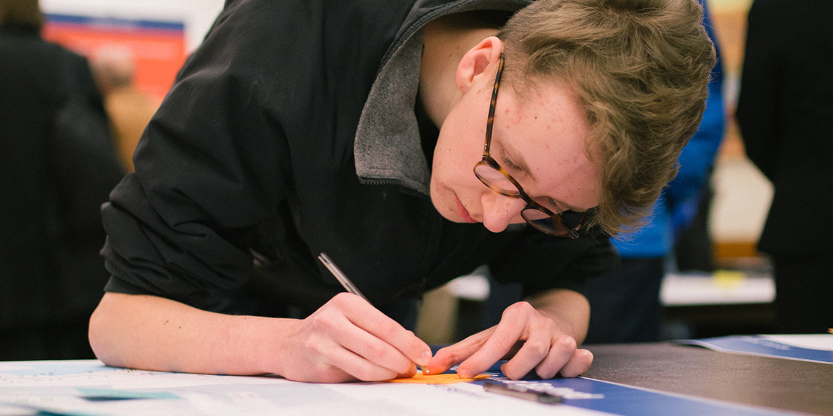 A resident writes down feedback at a West Seattle and Ballard Link Extensions open house.