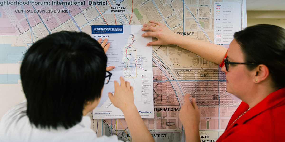 Residents look over a map of potential routes for the West Seattle and Ballard Link Extensions.