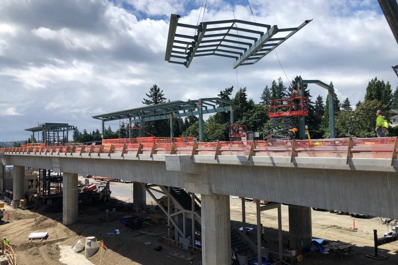 Construction crane places the structural steel forming the station canopy.