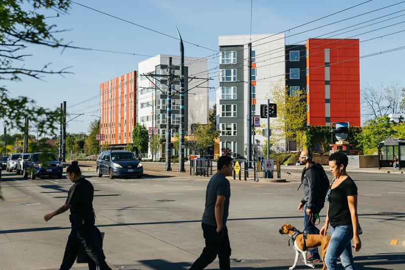 People walking with pets in front of Mercy Othello Plaza.