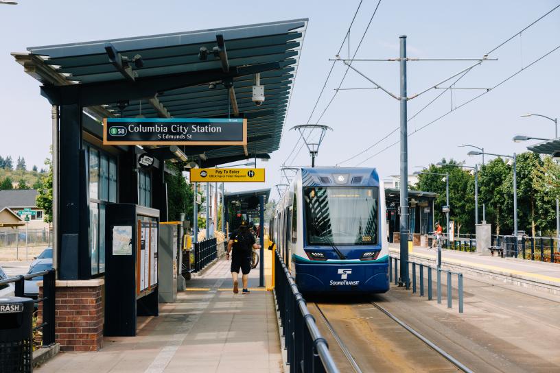A passenger taps their ORCA card on the way to board a 1 Line train at Columbia City Station. 