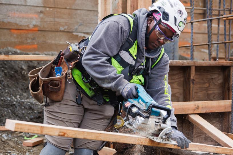 A worker uses a saw on a construction site
