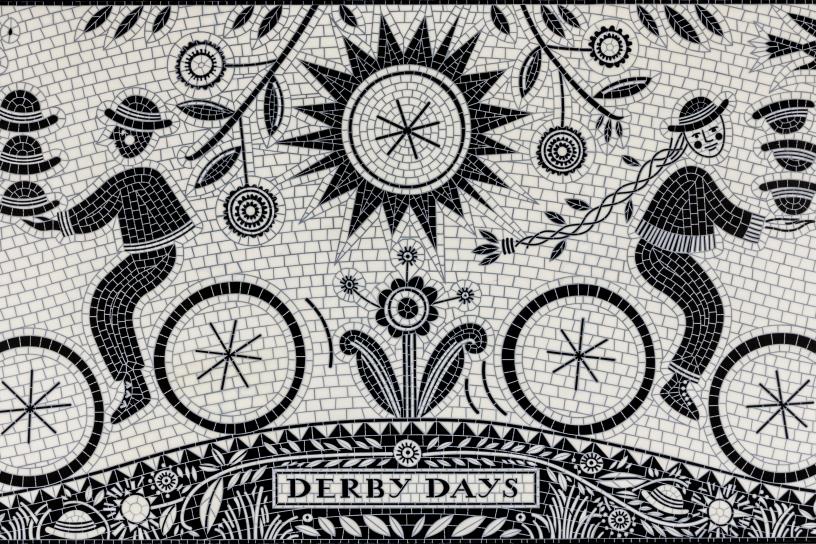 Black and white mosaic art shows two people on bicycles for "Derby Days."