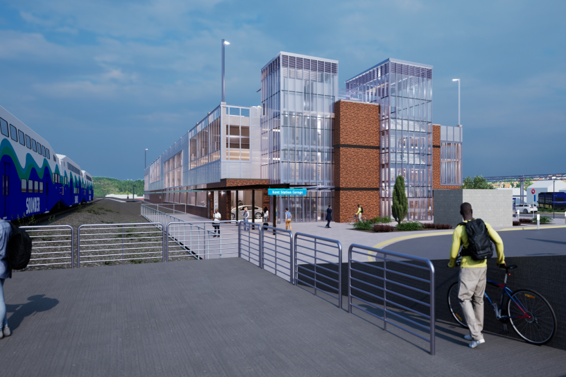 Digital rendering of the completed Kent Station parking garage viewed from the station platform. The multi-story garage includes glass elevator towers, architectural features, pedestrian pathways, landscaping, and direct connections to Sounder rail service. 