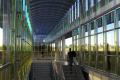 rendering of the glass art installation and a person riding up an escalator at the future Federal Way Downtown station