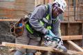 A worker uses a saw on a construction site