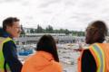 Three people in protective gear look at the construction on the Federal Way Link Extension