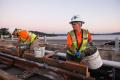 Workers on the I-90 bridge fill five-gallon buckets with concrete