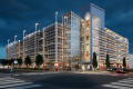 Nighttime digital rendering of the completed Auburn Station parking garage. The structure includes decorative exterior screening, a glass elevator tower with integrated public art, street trees, pedestrian crossings, and enhanced station-area lighting.