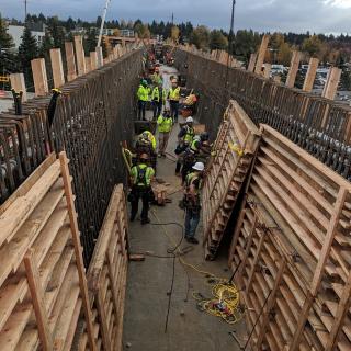 Crews busy inside the bridge over I-405 placing wood forms against the rebar cages waiting to be filled with concrete.