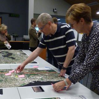 Community members look at maps and ask questions at an I-405 Bus Rapid Transit community meeting.