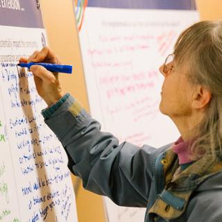 A community member makes notes on a project display for the West Seattle and Ballard Link Extension project.