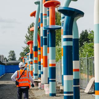 A man walking next to the 20-foot tall "nails" sculpture along the Eastrail Trail in Bellevue.