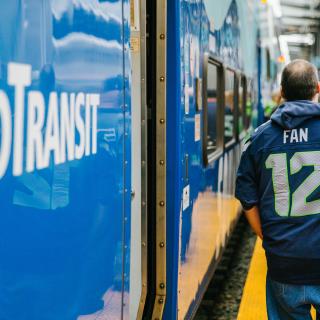 A Seahawks fan walks next to a Sounder train.