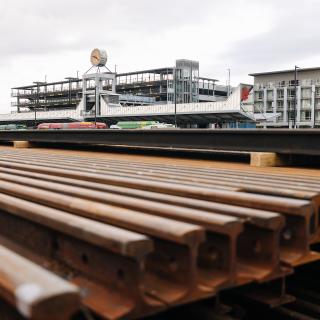 A stack of rail in the foreground, with the Federal Way Transit Center in the background.