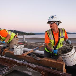 Workers on the I-90 bridge fill five-gallon buckets with concrete