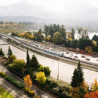 A drone shot of train testing on Mercer Island with trees in beautiful fall colors in the foreground