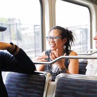 Three people sit and chat with each other while on board a Link light rail vehicle
