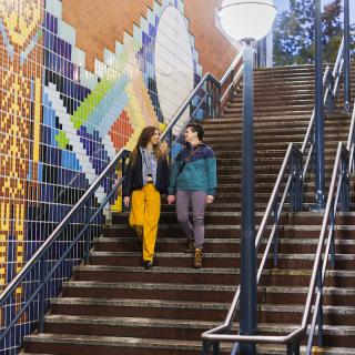 A couple walks down the stairs to Pioneer Square Station.
