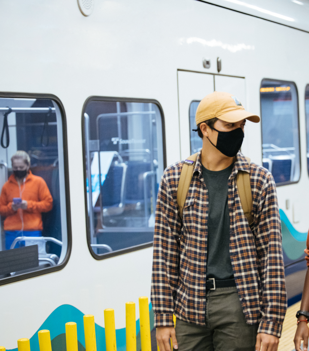 Link light rail riders on station platform with train in background.